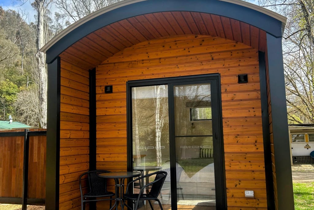 Modern timber pod cabin with outdoor seating at Bright Accommodation Park, Bright VIC