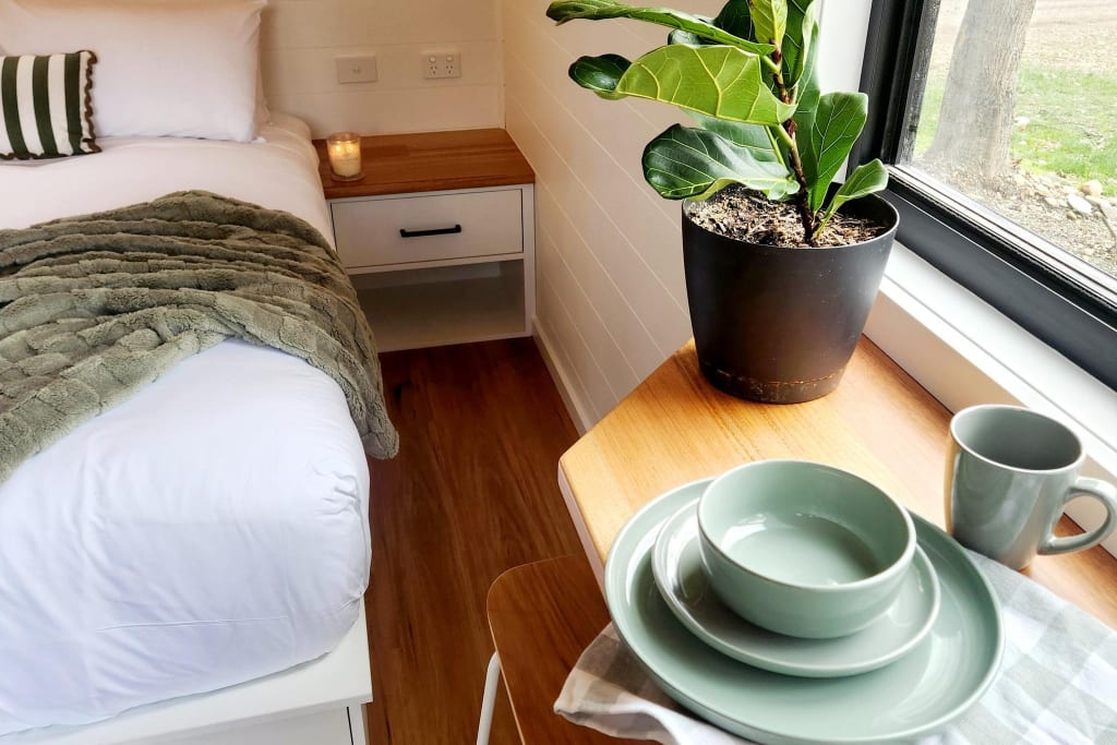 Modern pod interior at Bright Accommodation Park with queen bed, dining table and window seating
