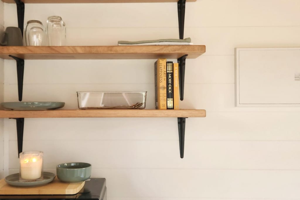 Timber wall shelves with candle and ceramics in modern pod accommodation at Bright Accommodation Park, Bright VIC
