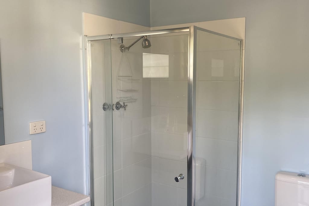 Modern ensuite bathroom with glass shower in cabin accommodation at Bright Accommodation Park, Victoria