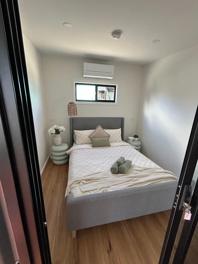 Modern bedroom with double bed, air conditioning and timber floors at Bright Accommodation Park, Bright VIC