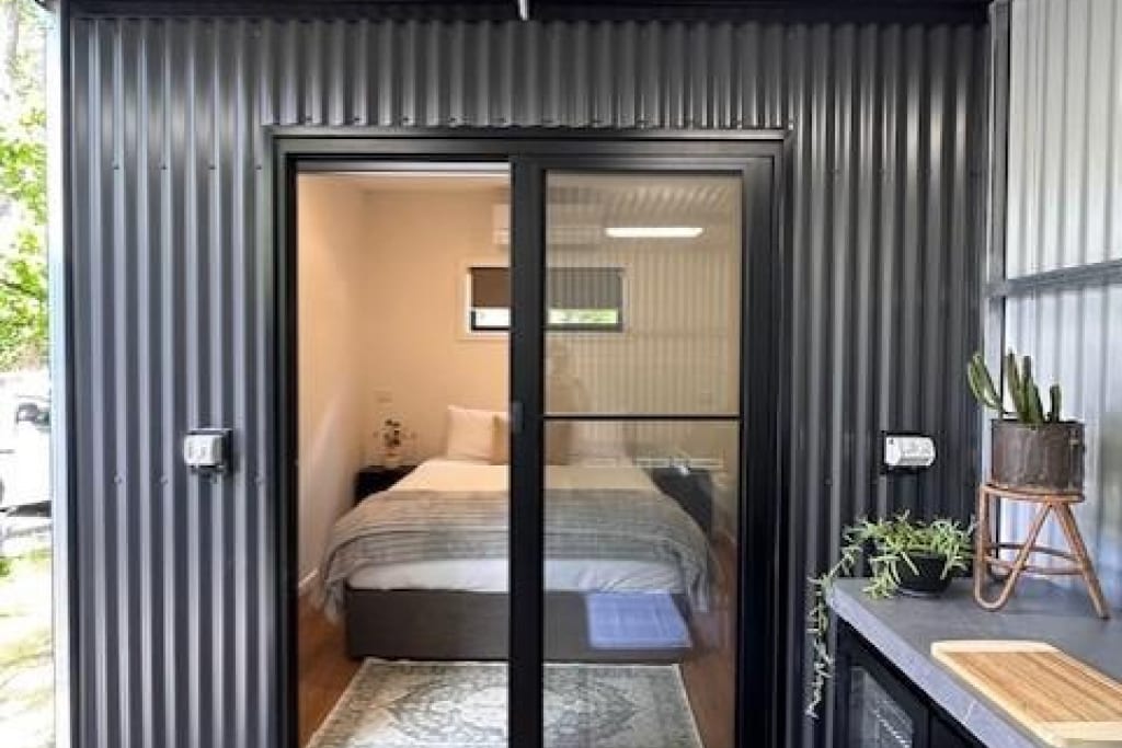 Modern cabin accommodation with glass doors and outdoor deck at Bright Accommodation Park, Bright Victoria