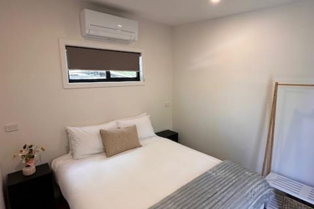 Contemporary bedroom with double bed, air conditioning and furnishings at Bright Accommodation Park, Bright