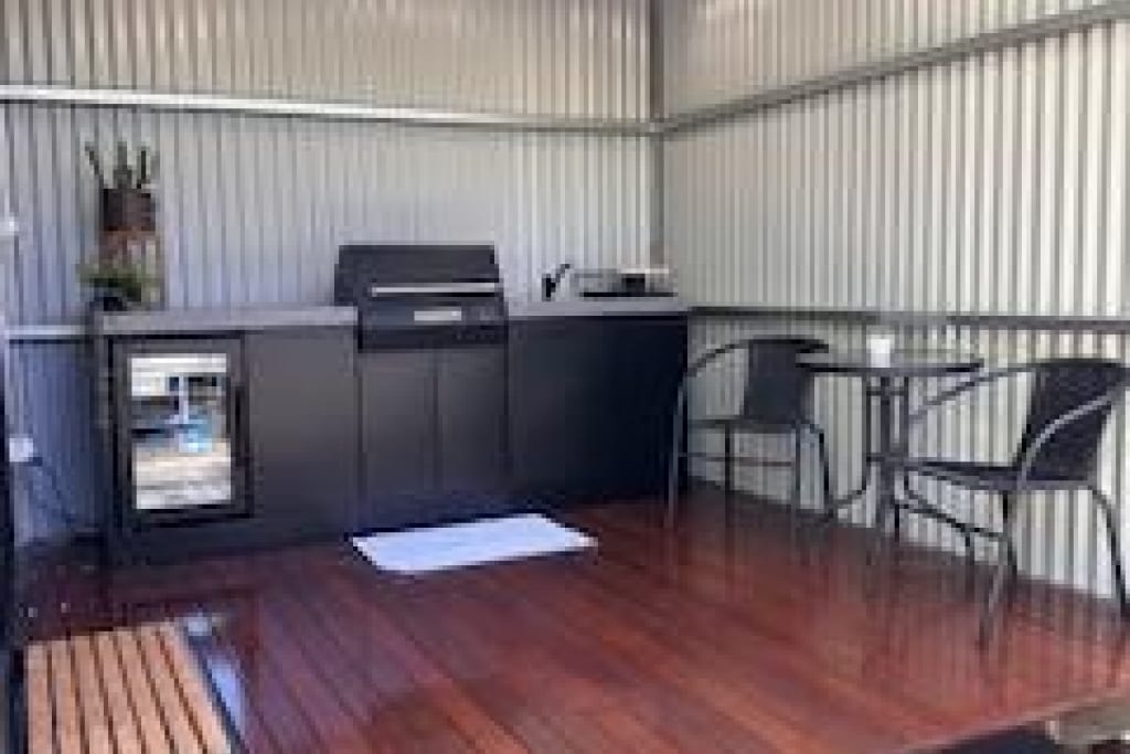 Covered BBQ and camp kitchen facility at Bright Accommodation Park with modern gas grill and seating area