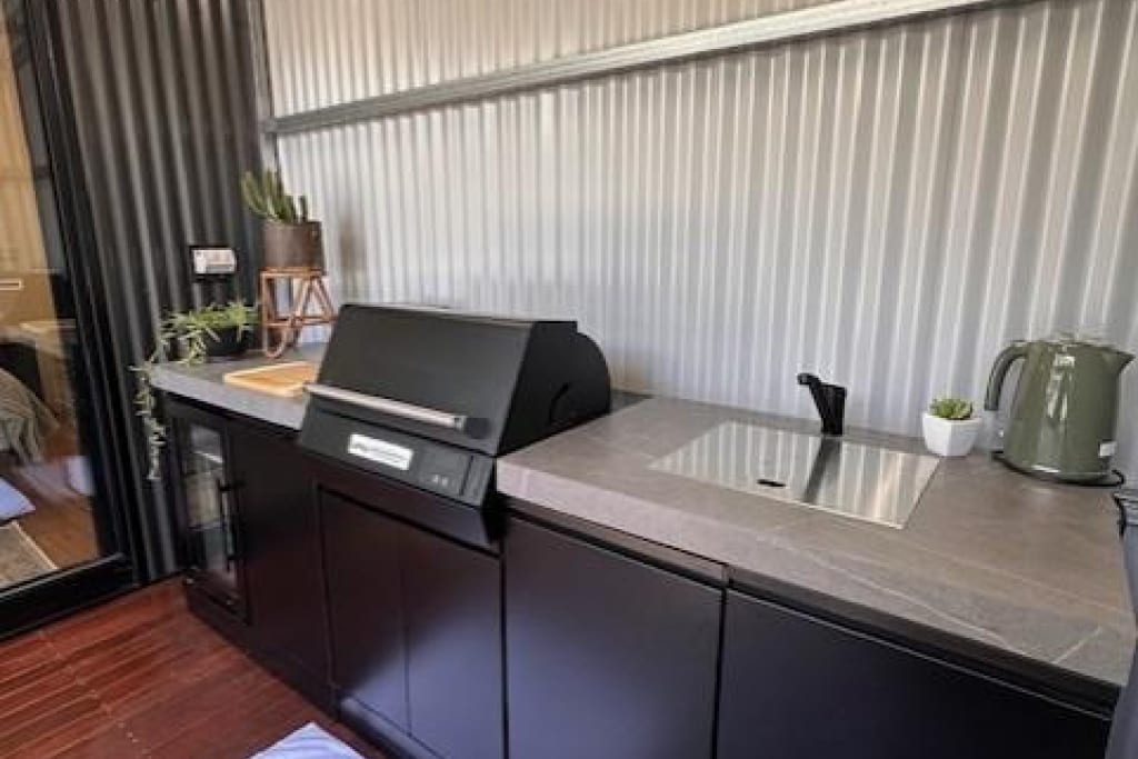 Outdoor camp kitchen with BBQ grill, sink and benchtop at Bright Accommodation Park in Bright, Victoria