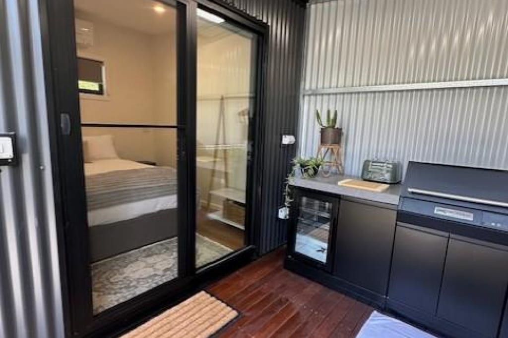 Modern cabin interior with kitchenette and bedroom at Bright Accommodation Park, Bright VIC