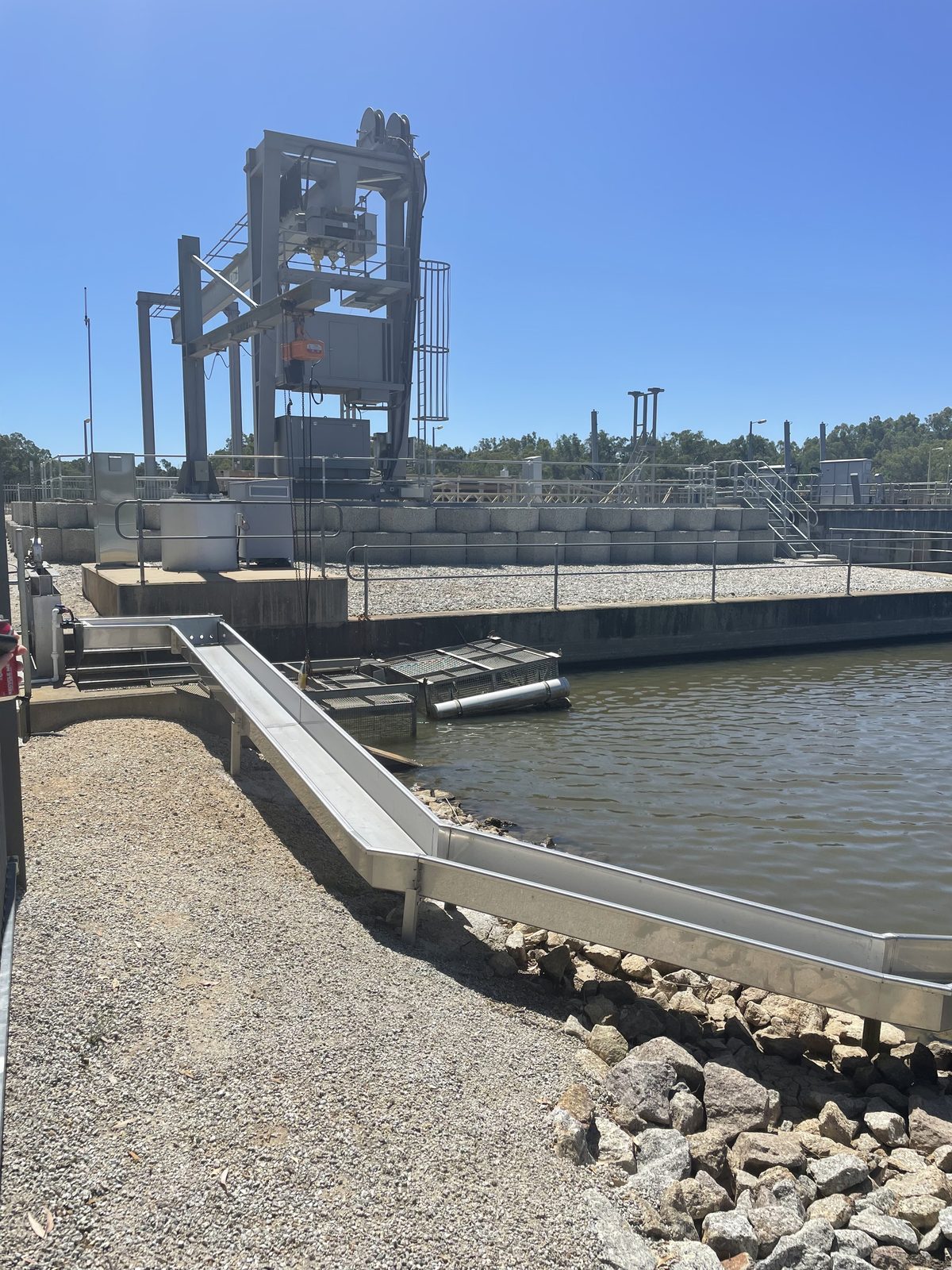 Torrumbarry weir gantry and concrete spillway channel beside the river at Torrumbarry Weir Holiday Park