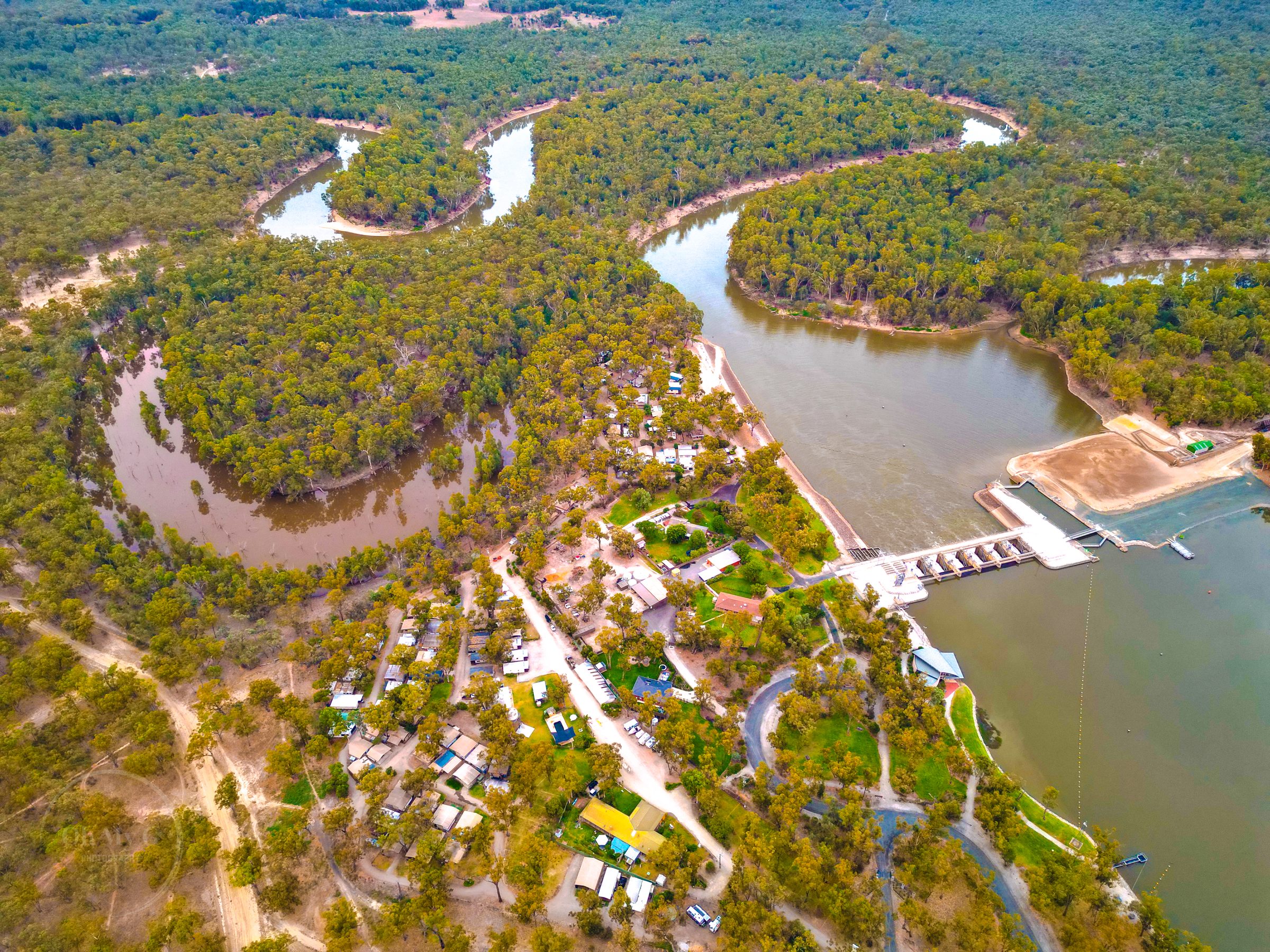 Aerial of the murray river bend and weir through red gum forest at Torrumbarry Weir Holiday Park