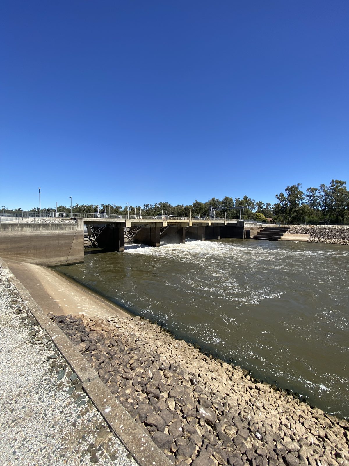 Torrumbarry weir wall and spillway channel from the rocky bank at Torrumbarry Weir Holiday Park