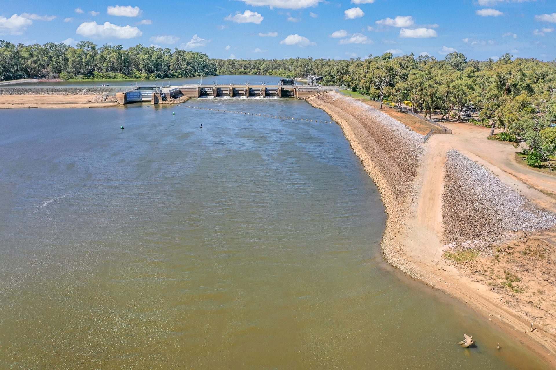 Low aerial over the river looking towards the weir wall at Torrumbarry Weir Holiday Park