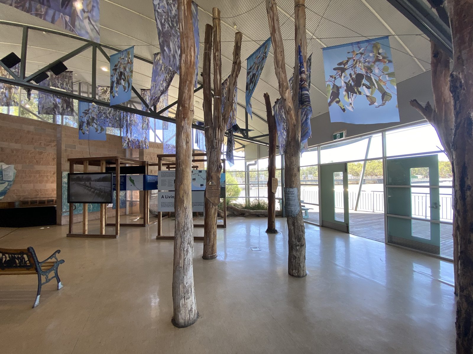Visitor centre interior with timber pole columns and display panels at Torrumbarry Weir Holiday Park