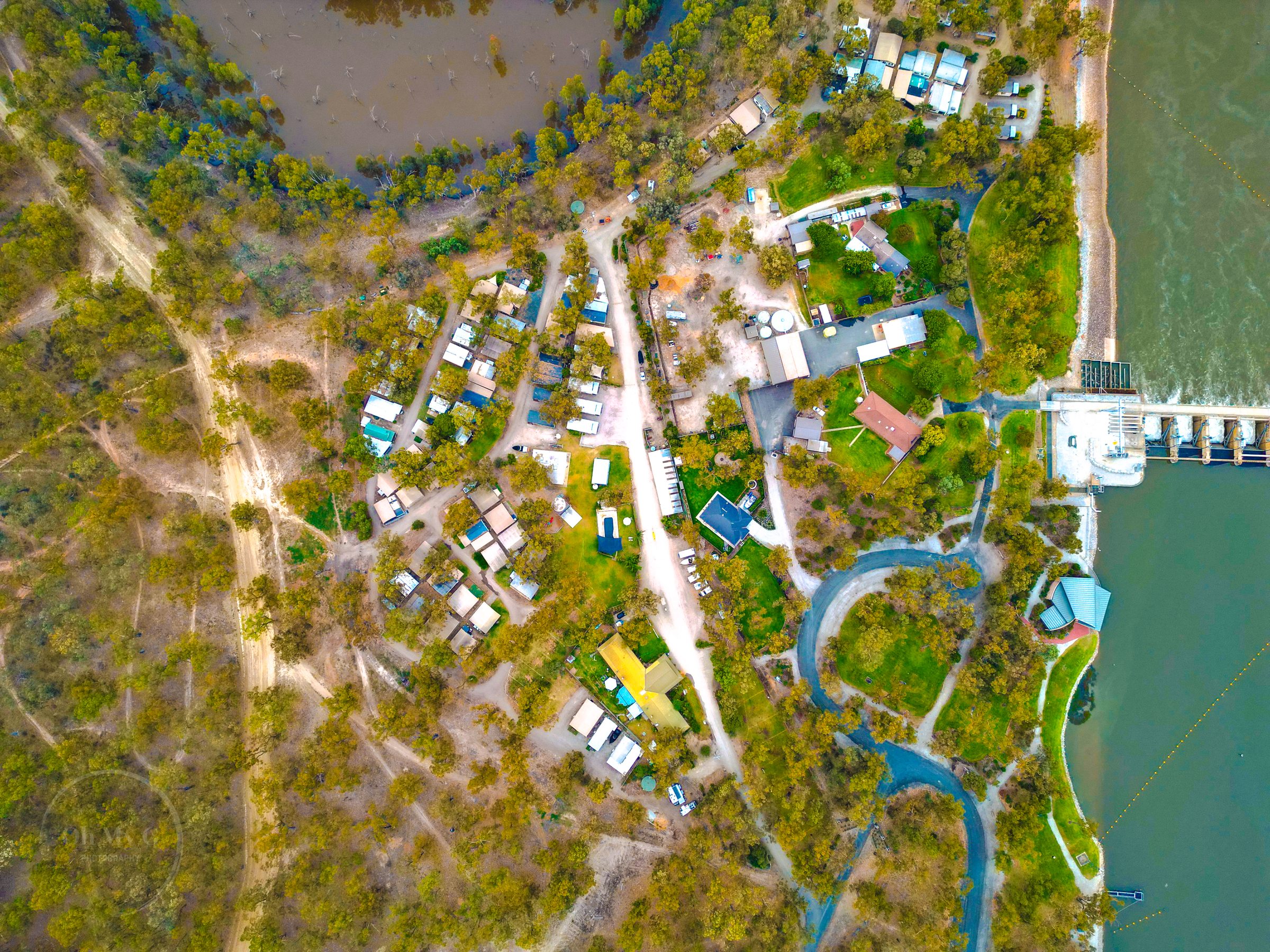 Aerial of park layout with pool cabins and weir beyond at Torrumbarry Weir Holiday Park