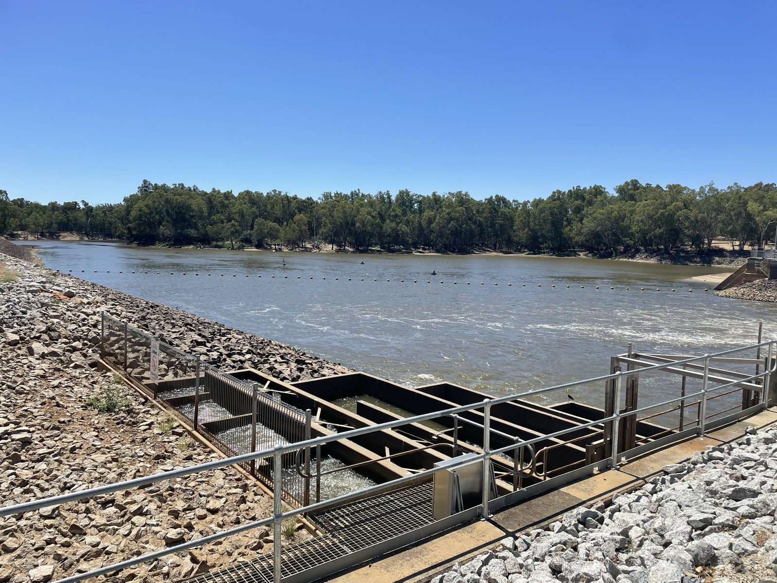 Fishway and rock apron with the murray river stretching upstream at Torrumbarry Weir Holiday Park