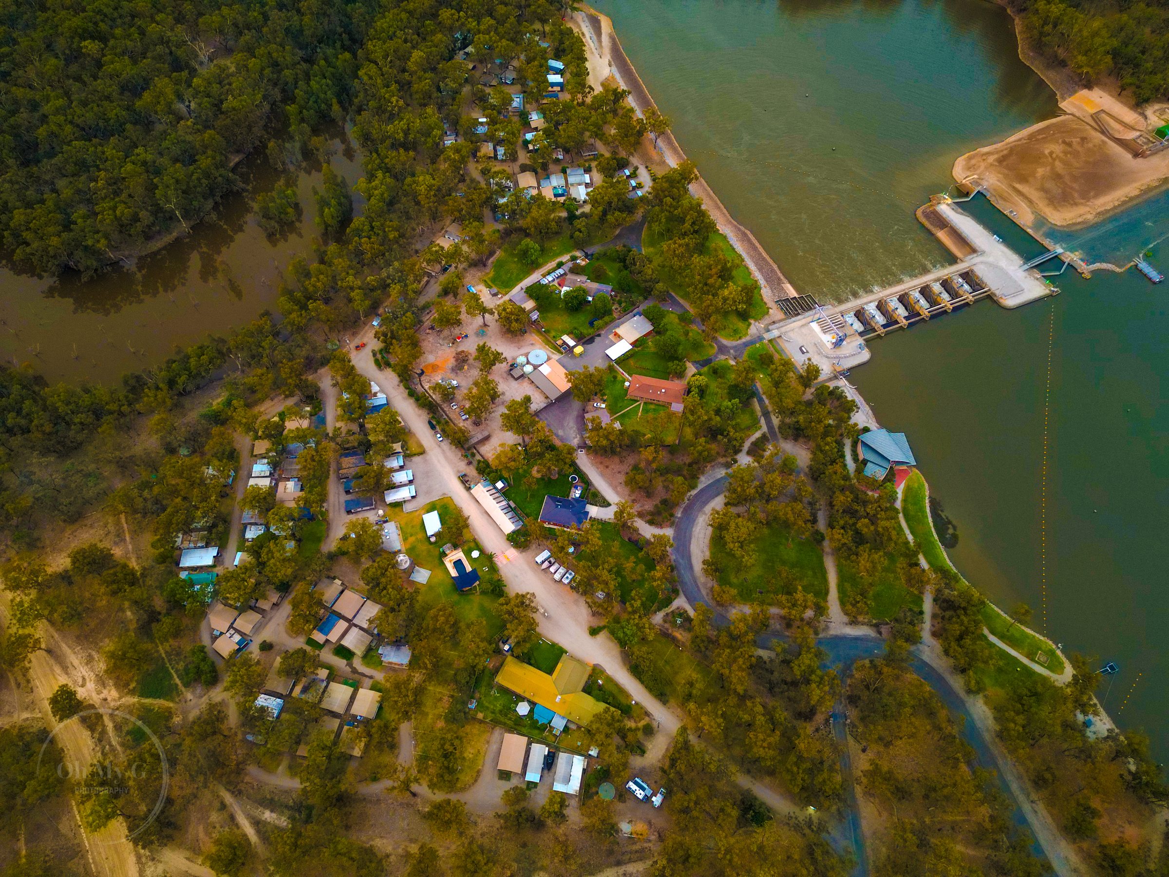 Aerial of park cabins pool and boat ramp beside the river at Torrumbarry Weir Holiday Park