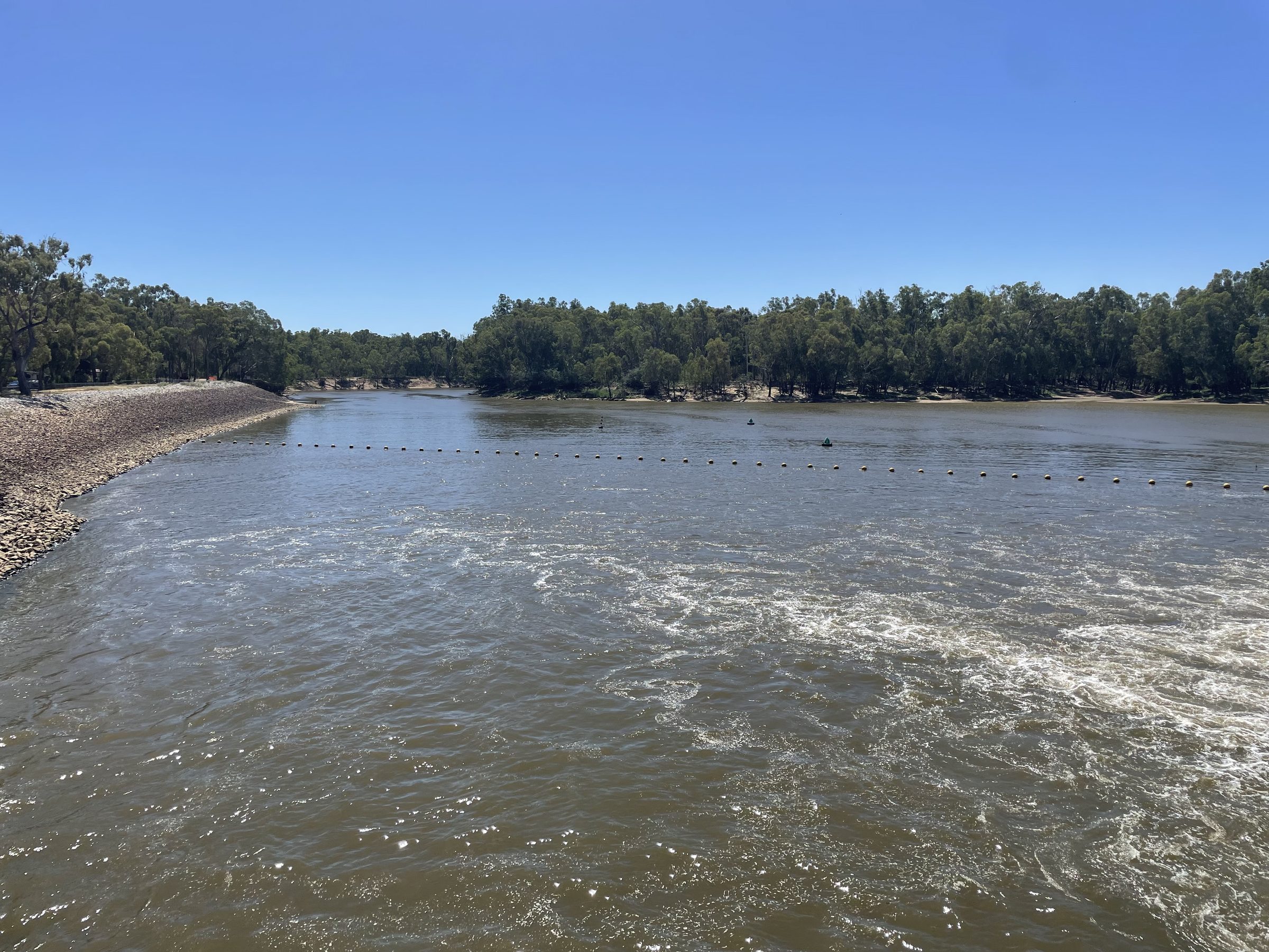 Water pouring over torrumbarry weir wall across the wide murray at Torrumbarry Weir Holiday Park