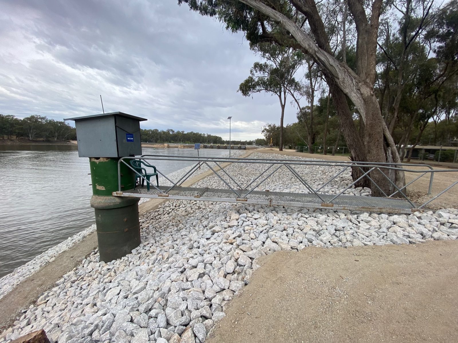 Rock-armoured river bank with steel walkway and boat ramp at Torrumbarry Weir Holiday Park on the Murray River, Patho VIC