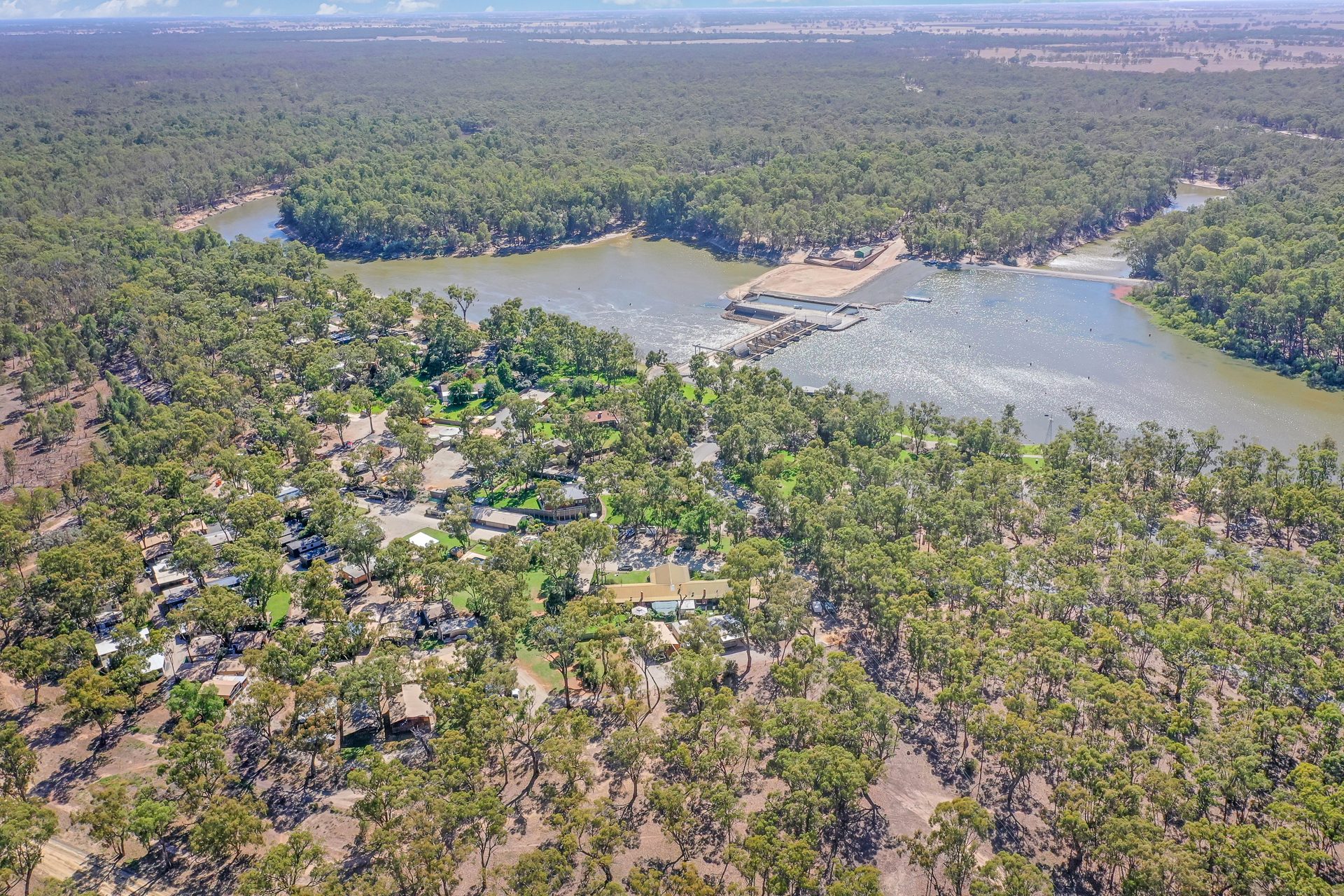High aerial of park among red gums on the murray river bend at Torrumbarry Weir Holiday Park