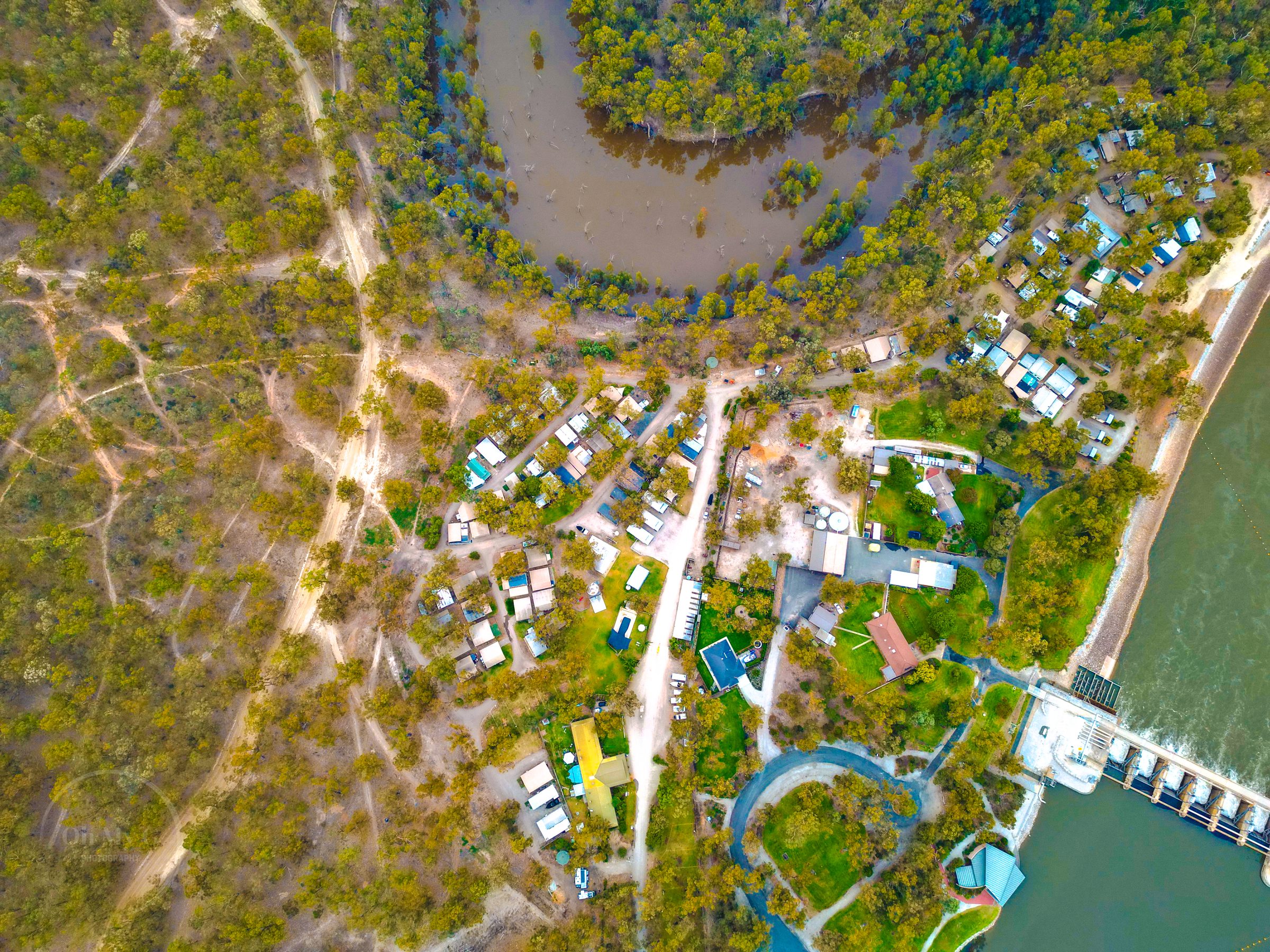 Aerial of park cabins pool roads and weir on the river at Torrumbarry Weir Holiday Park