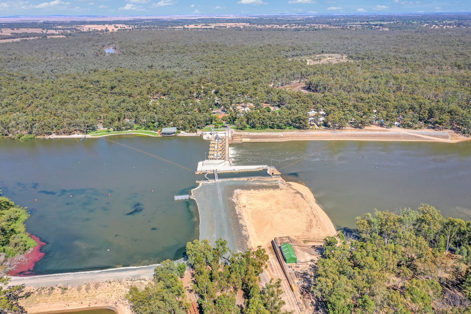 Aerial of weir lock structure gates road and works sheds at Torrumbarry Weir Holiday Park