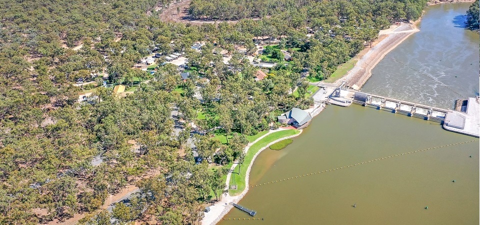 Aerial view of Torrumbarry Weir Holiday Park at Patho VIC, riverside caravan park nestled among gums beside the weir